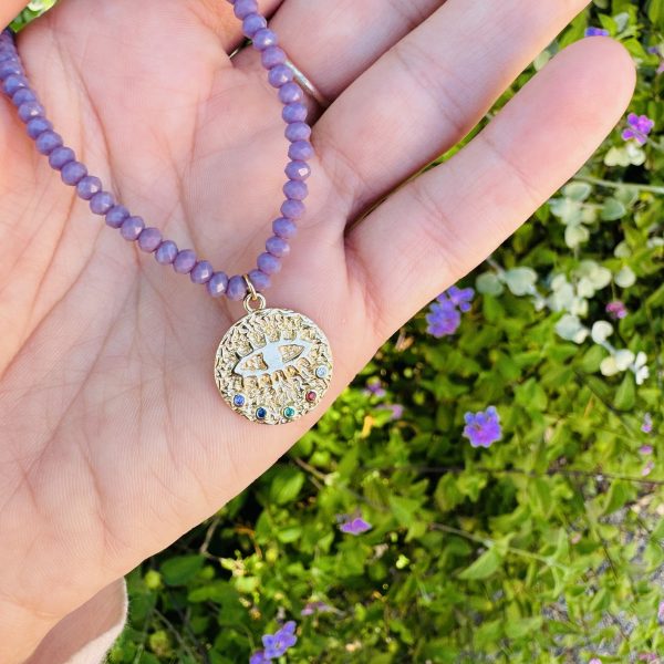 Colar em tom lilás com pingente de olho protetor, símbolo de proteção e energia positiva. Inspirado no vento Maestral,